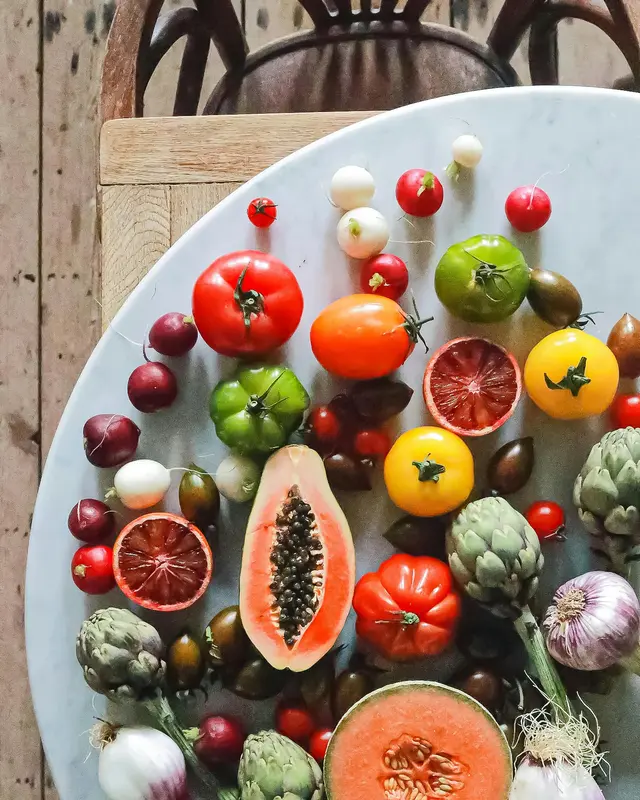 Table of a variety of fruit, some whole, some cut open