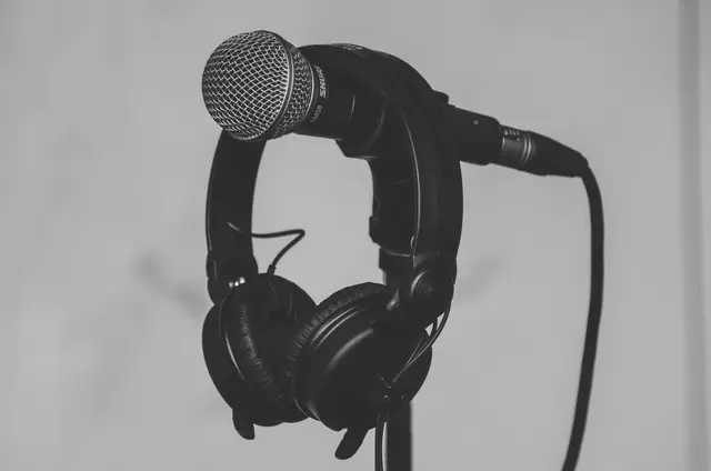 Headphones hanging on a microphone stand with the microphone